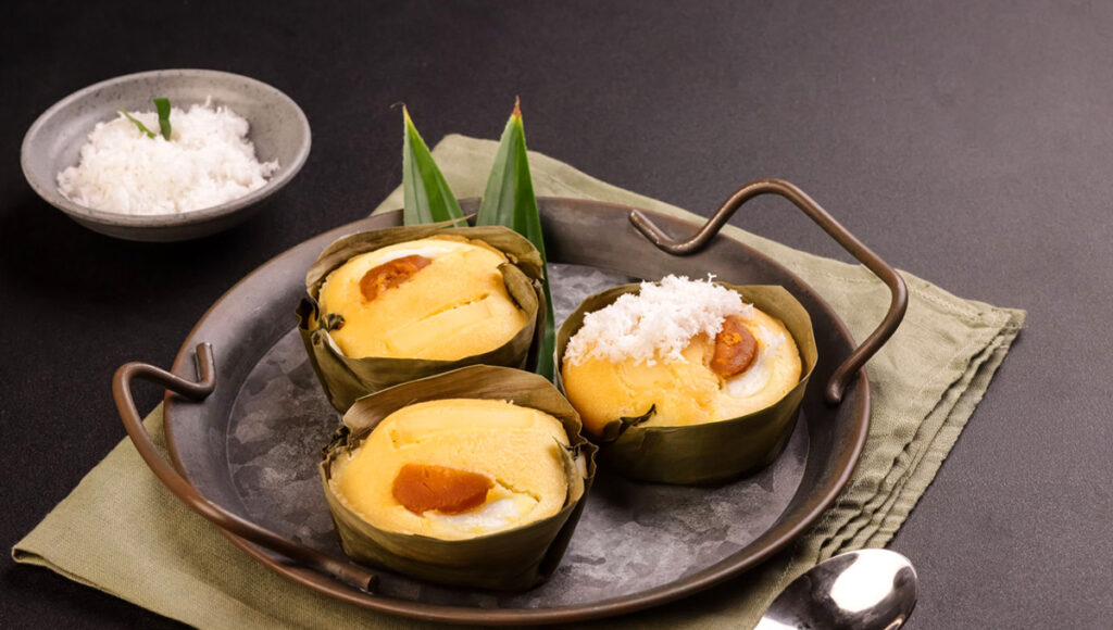 A Bibingka rice cake, a classic example of Filipino Christmas food, topped with butter and salted egg on a banana leaf