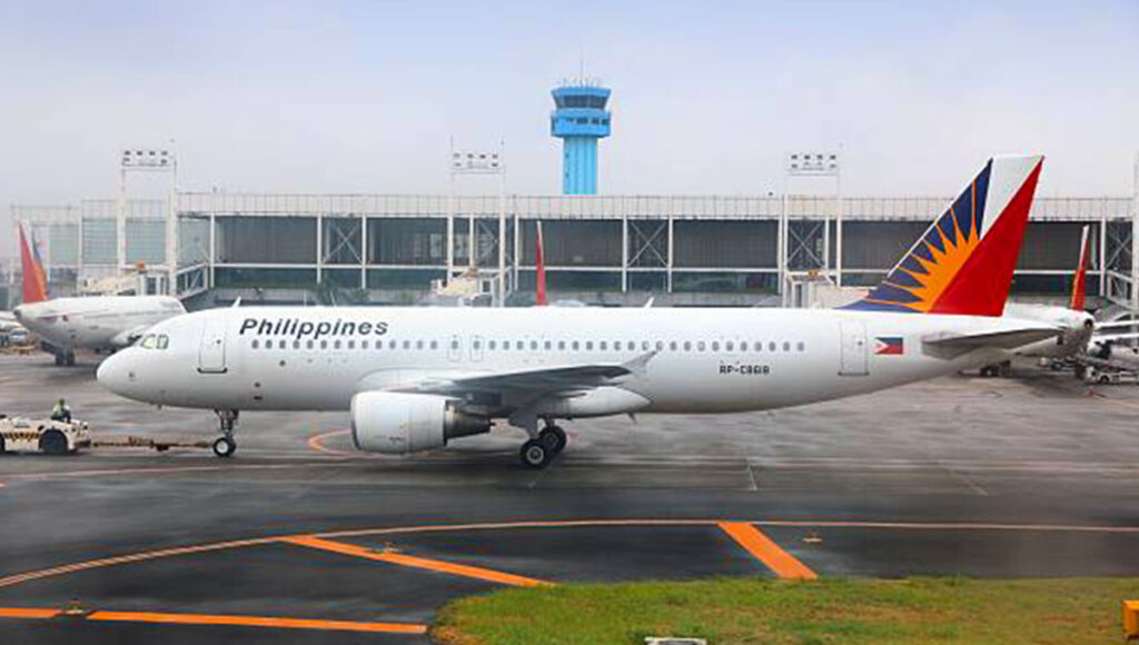 Philippine Airlines aircraft parked at Manila Airport with boarding gates visible, showing the hub for travelers booking direct flights to Philippines from UK.