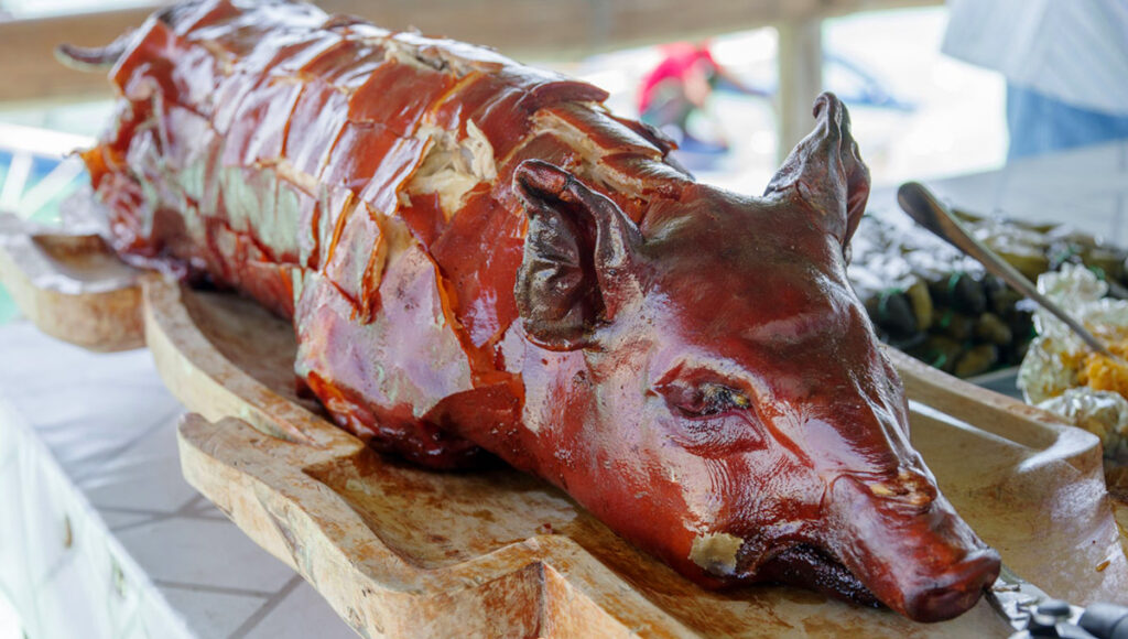 A table with a whole roasted pig (lechon) as the centrepiece, which is often enjoyed during the Sinulog festival.