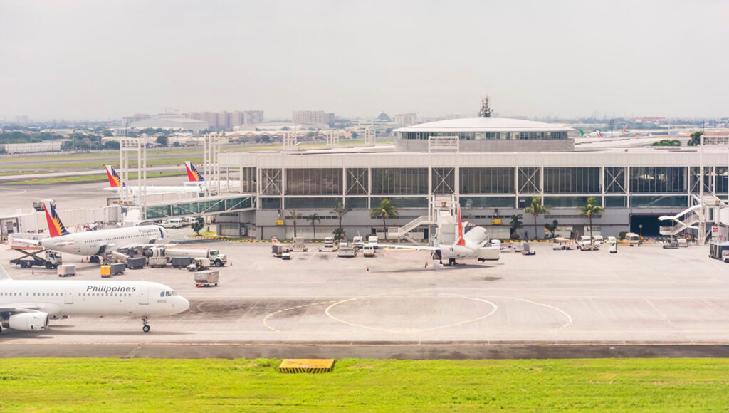 View of Manila International Airport (NAIA) Terminal 2, showing runways, tarmac, and airport infrastructure for international travelers taking direct flights to Philippines from UK.