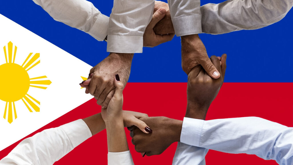 A diverse group of hands, interlocking and forming a circle, symbolizing unity and community, superimposed against the vibrant red, white, and blue flag of the Philippines with its golden sun emblem, representing the spirit of Filipino culture and solidarity.