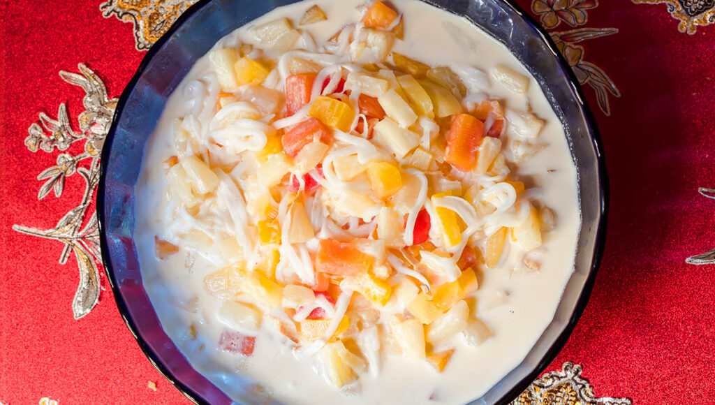 A bowl of Buko Salad, a creamy fruit dessert and a favorite Filipino Christmas food, made with young coconut and tropical fruits