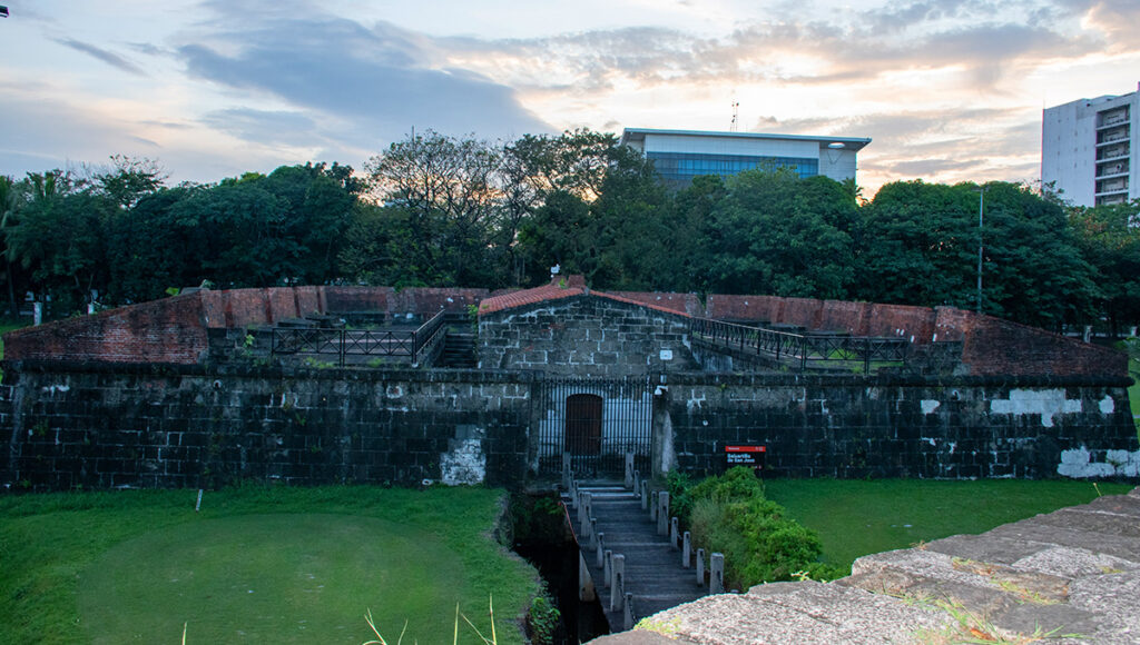 The historic stone and brick wall of Intramuros, showing the heritage district for where to stay in Manila.
