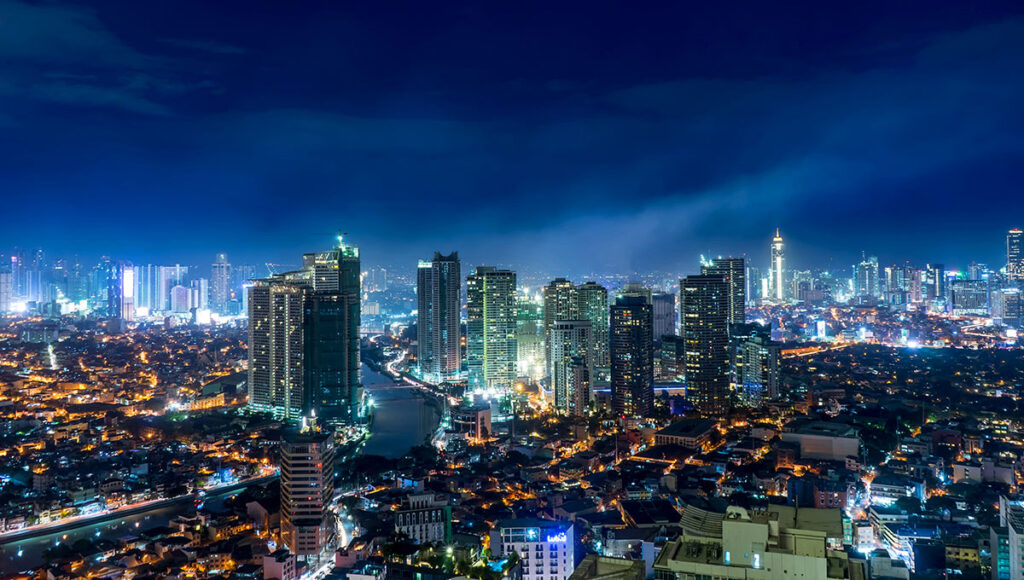 Spectacular night view of the illuminated Manila City skyline, showcasing the bustling modern metropolis and dynamic urban center that is home to many popular tourist attractions in Manila.