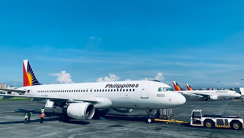 Philippine Airlines aircraft parked at Manila Ninoy Aquino International Airport, highlighting the national carrier many travellers compare when searching for the cheapest flight to the Philippines.