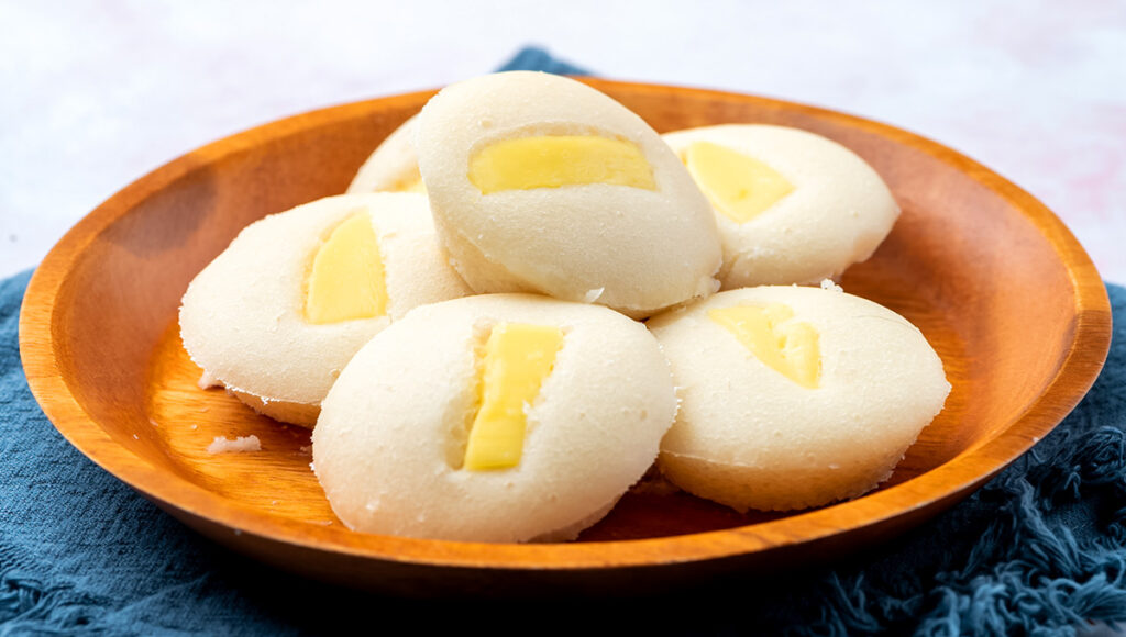 A close‑up of soft, fluffy cheese‑topped puto rice cakes, a sweet finale for a classic Boodle Fight Philippines feast.