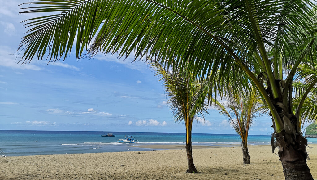 Undiscovered beaches in the Philippines showing Sugar Beach in Sipalay with golden-brown sand, calm waters, and a peaceful tropical setting