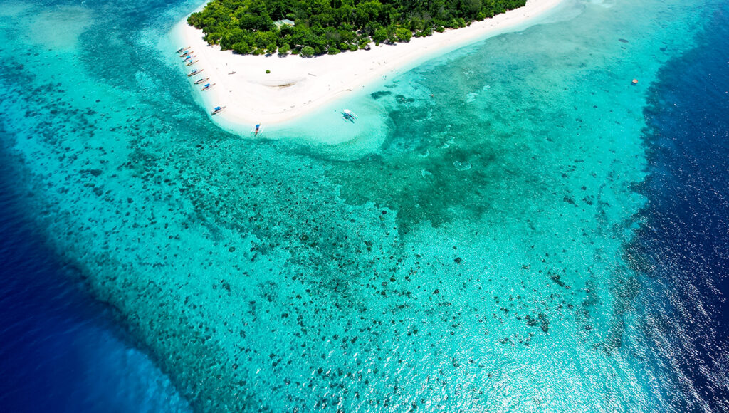 Undiscovered beaches in the Philippines on Mantigue Island in Camiguin featuring white sand, coral reefs, and clear volcanic waters