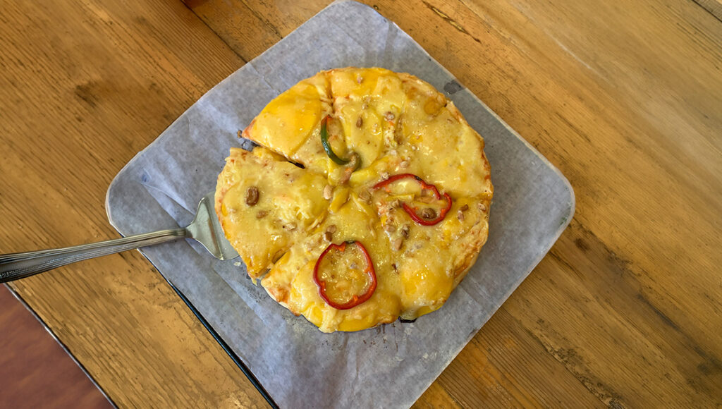 Mango pizza topped with cheese and bell pepper.