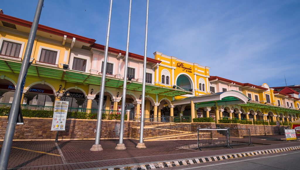 The Spanish-Italian inspired facade of Plazuela de Iloilo with its bright yellow walls and open-air corridors, a major shopping and dining destination for those seeking things to do in Iloilo City.