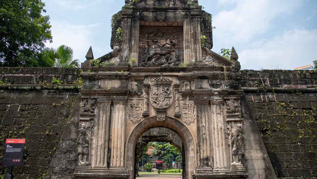 The iconic stone entrance of Fort Santiago in Intramuros, showcasing Spanish-era architecture and historical carvings found on city-based day trips from Manila.