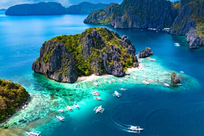 Aerial view of turquoise waters and limestone cliffs in El Nido, Palawan, showcasing the tropical environment to consider when deciding what to pack to Philippines.