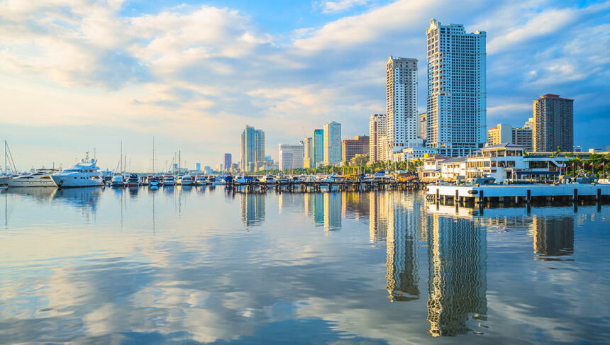A panoramic view of the Manila skyline at sunset, showcasing modern buildings and Manila Bay, perfect for highlighting things to do in Manila for travellers.