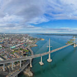 Aerial panoramic view of the massive Cebu City skyline, modern cable-stayed bridge, and harbor, showing the urban side of where to stay in Cebu.