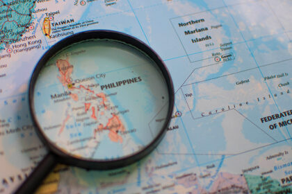 Detailed geographical map of the Philippines under a magnifying glass, illustrating the archipelagic nature of the country. A visual aid for discovering fascinating fun facts about the Philippines and its unique location in Southeast Asia.