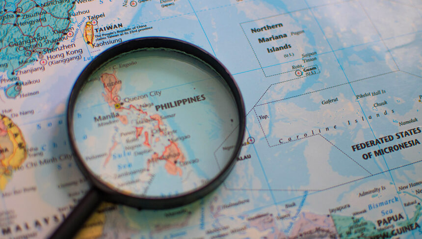 Detailed geographical map of the Philippines under a magnifying glass, illustrating the archipelagic nature of the country. A visual aid for discovering fascinating fun facts about the Philippines and its unique location in Southeast Asia.