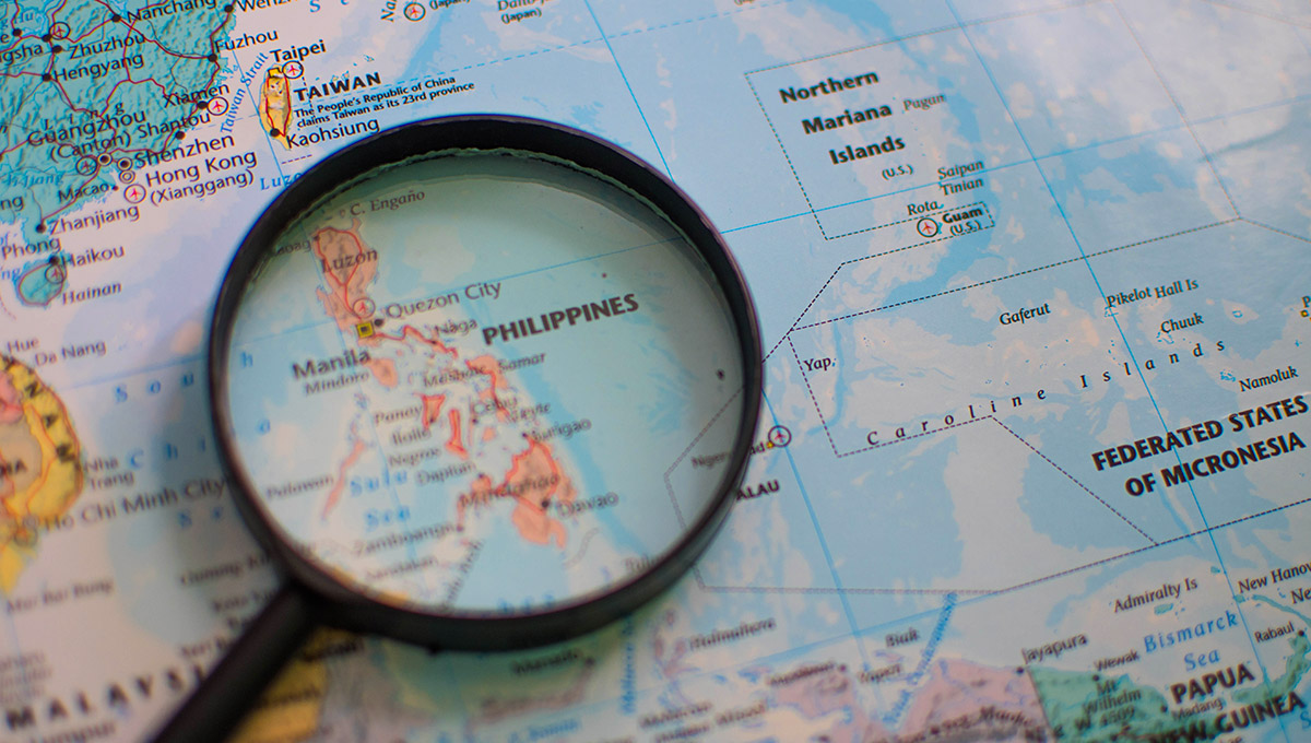 Detailed geographical map of the Philippines under a magnifying glass, illustrating the archipelagic nature of the country. A visual aid for discovering fascinating fun facts about the Philippines and its unique location in Southeast Asia.