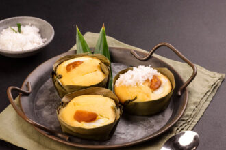 A Bibingka rice cake, a classic example of Filipino Christmas food, topped with butter and salted egg on a banana leaf