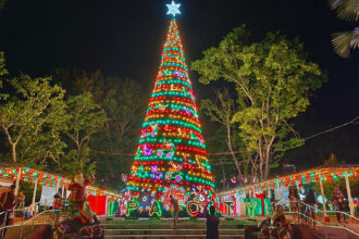A magnificent, brightly lit Christmas tree adorned with colourful lights and a shining star, illuminating a public square at night in the Philippines. This festive scene is a perfect visual for illustrating fun facts about the Philippines' incredibly long and joyous Christmas season, which famously begins in September.