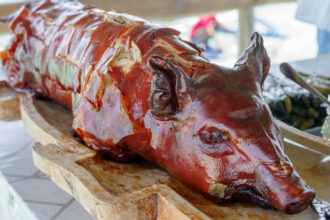 A table with a whole roasted pig (lechon) as the centrepiece, which is often enjoyed during the Sinulog festival.