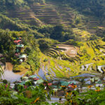 Terraced rice paddies and small villages nestled in the lush green mountains of the Philippines, showcasing what is Philippines famous for: its stunning agricultural landscapes and natural beauty.