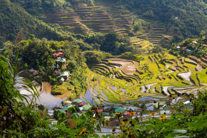 Terraced rice paddies and small villages nestled in the lush green mountains of the Philippines, showcasing what is Philippines famous for: its stunning agricultural landscapes and natural beauty.