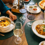 Top view of hands sharing pizza at a table, inspired by dishes you might find at the best restaurants in Manila