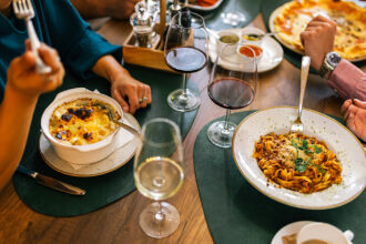 Top view of hands sharing pizza at a table, inspired by dishes you might find at the best restaurants in Manila