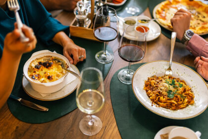 Top view of hands sharing pizza at a table, inspired by dishes you might find at the best restaurants in Manila