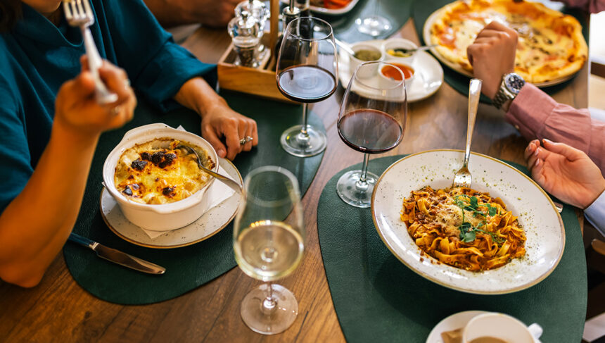 Top view of hands sharing pizza at a table, inspired by dishes you might find at the best restaurants in Manila