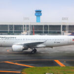 Philippine Airlines airplane parked at Manila airport, with passengers preparing their luggage according to Philippines Airlines baggage allowance rules.