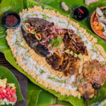 Grilled seafood and meats served on banana leaves during a traditional Boodle Fight Philippines feast.