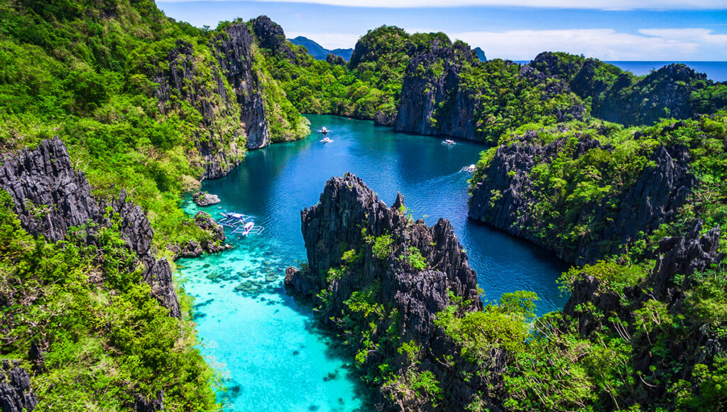 Aerial view of El Nido, Palawan with limestone islands and turquoise water, evoking tropical beauty like famous waterfalls in the Philippines.