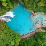 Aerial view of stunning waterfalls in the Philippines at Kawasan Falls in Cebu with turquoise cascades surrounded by lush tropical forest.