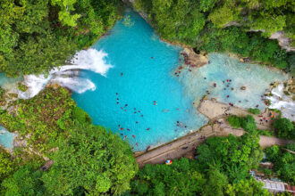 Aerial view of stunning waterfalls in the Philippines at Kawasan Falls in Cebu with turquoise cascades surrounded by lush tropical forest.