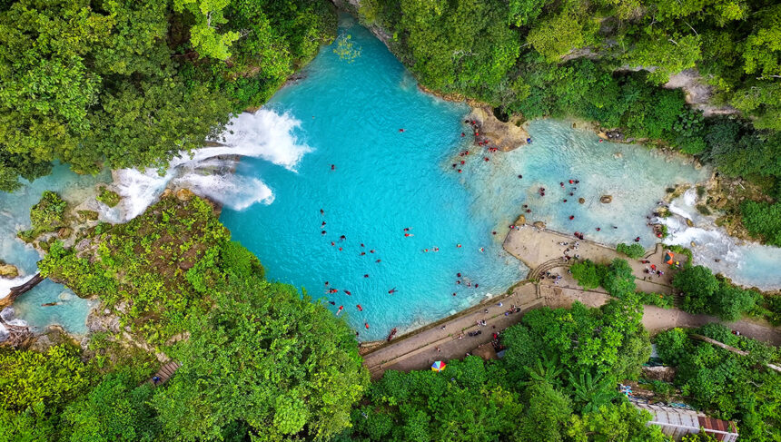 Aerial view of stunning waterfalls in the Philippines at Kawasan Falls in Cebu with turquoise cascades surrounded by lush tropical forest.