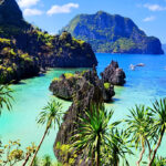 Tropical turquoise waters and limestone karst formations at one of the famous Palawan beaches in El Nido.