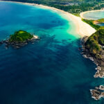 An aerial view of the twin beaches of Nacpan and Calitang, showcasing the golden sands and blue waters of Palawan beaches.