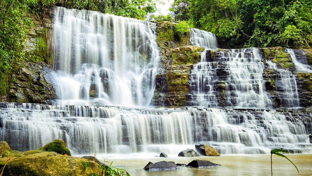 Two tiered Merloquet Falls cascading over unique rock formations in Zamboanga, showcasing why natural wonders are must see places to visit in Zamboanga for nature lovers.