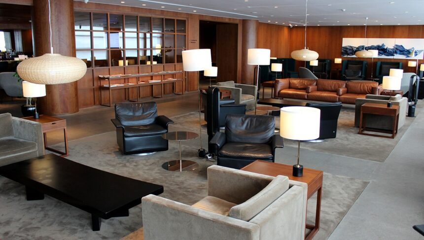 A luxury Manila airport lounge featuring mid-century modern leather armchairs, warm wood paneling, and ambient designer lighting for premium passenger comfort.
