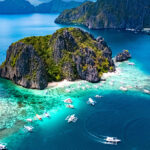 Aerial view of a Shimizu Island near El Nido and outrigger boats, one of the top things to do in Palawan for island hoppers.