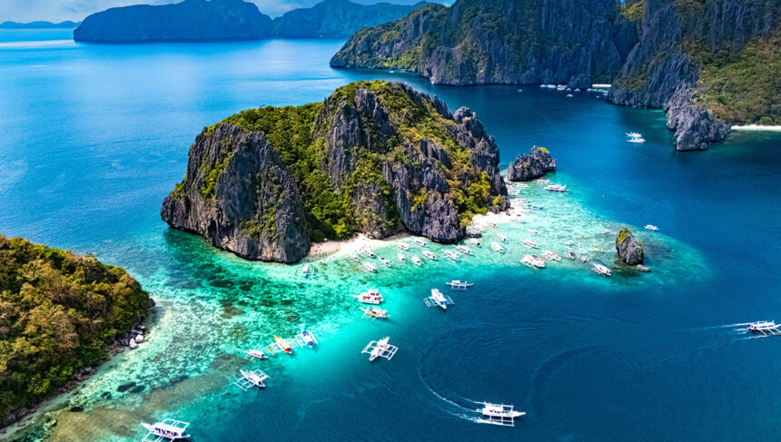 Aerial view of a Shimizu Island near El Nido and outrigger boats, one of the top things to do in Palawan for island hoppers.