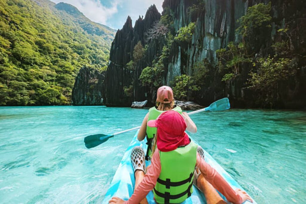 Family kayaking through a tropical lagoon while enjoying Getting Around the Philippines by water