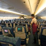 Flight attendant assisting passengers while travelling on cheap domestic flights Philippines