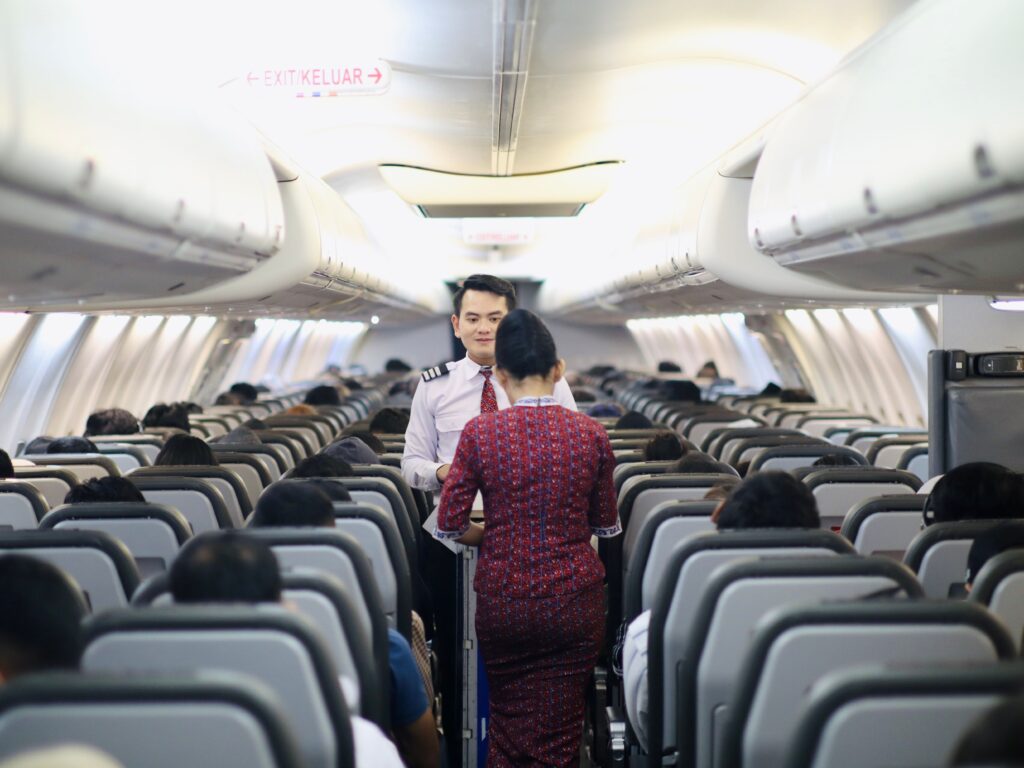 Cebu Pacific vs Philippine Airlines: Flight attendants serving passengers inside an aircraft cabin
