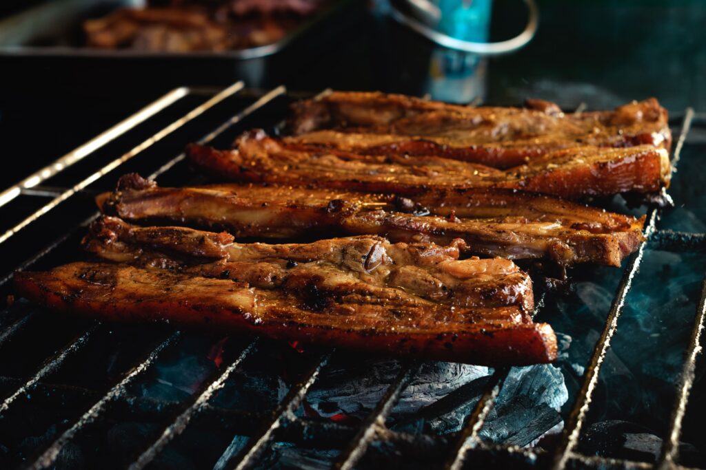 Grilled pork belly sizzling over charcoal during a Philippines honeymoon food adventure