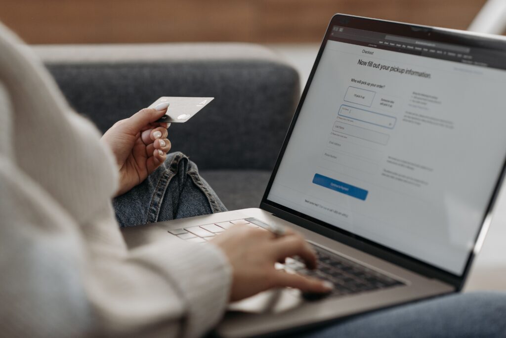 Woman using a credit card and laptop to explore Philippines Currency and manage travel expenses