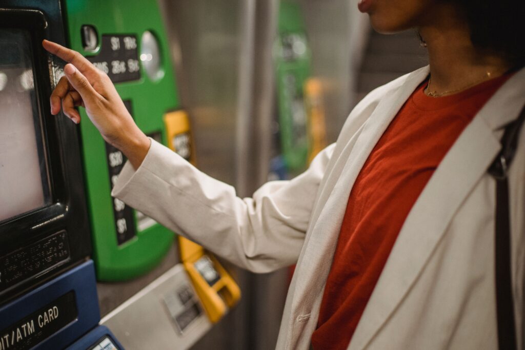 Person using an ATM for cash withdrawals while learning about Philippines Currency