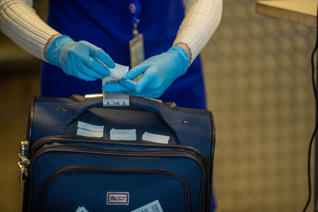 AirAsia Philippines Baggage Allowance: Airport staff inspecting luggage tags at a security checkpoint