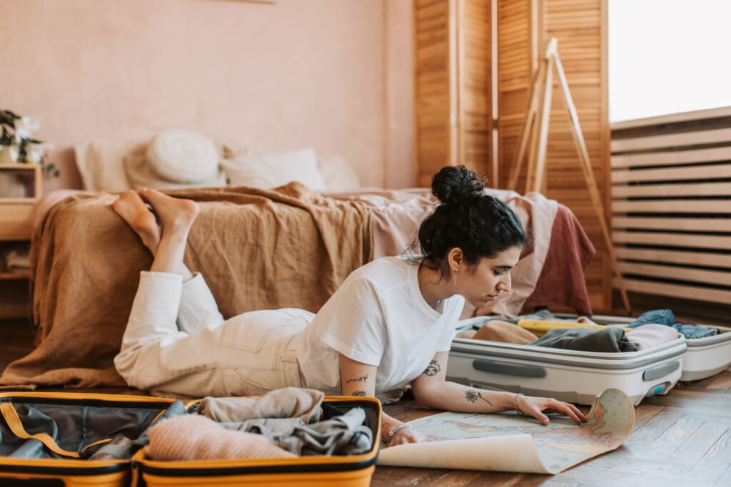 Woman planning a Philippines family holiday with a map and open suitcases